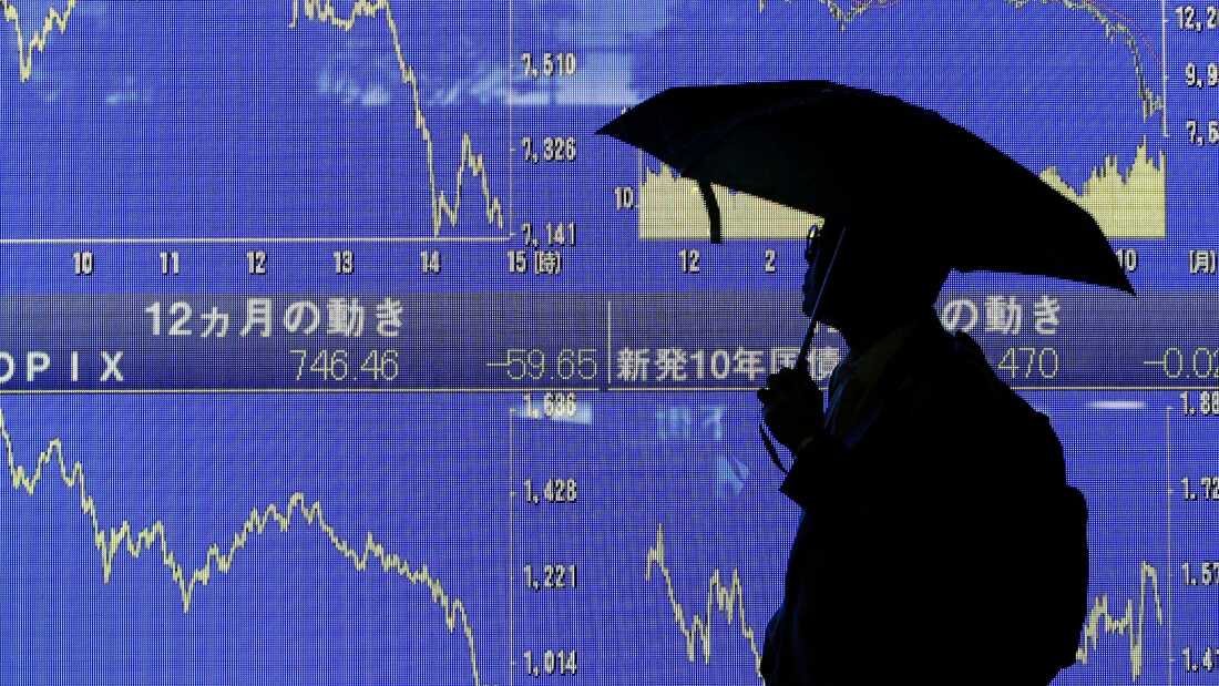 Un homme regarde un tableau électronique montrant la tendance à la baisse de la moyenne de l'action Nikkei japonaise le 27 octobre 2008 à Tokyo, au Japon.