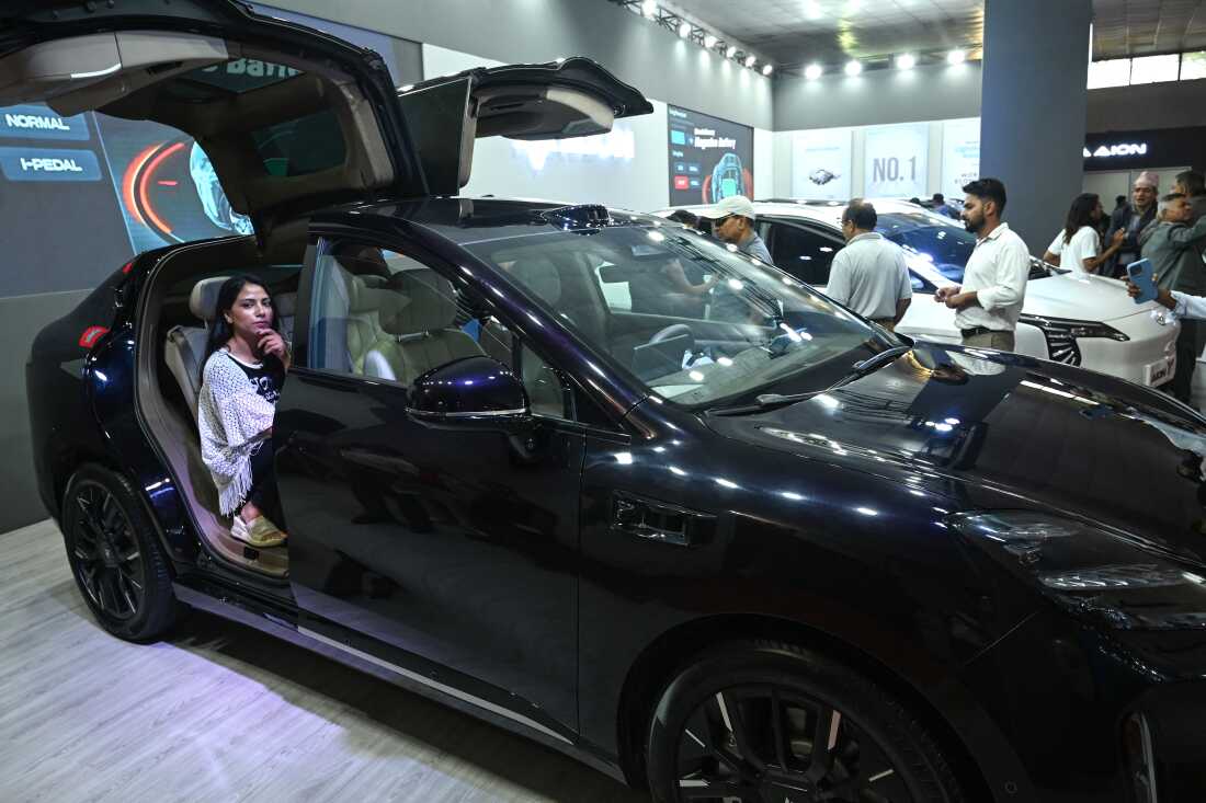 Sur cette photographie prise le 1er septembre 2024, des visiteurs regardent des véhicules électriques à Katmandou, au Népal.