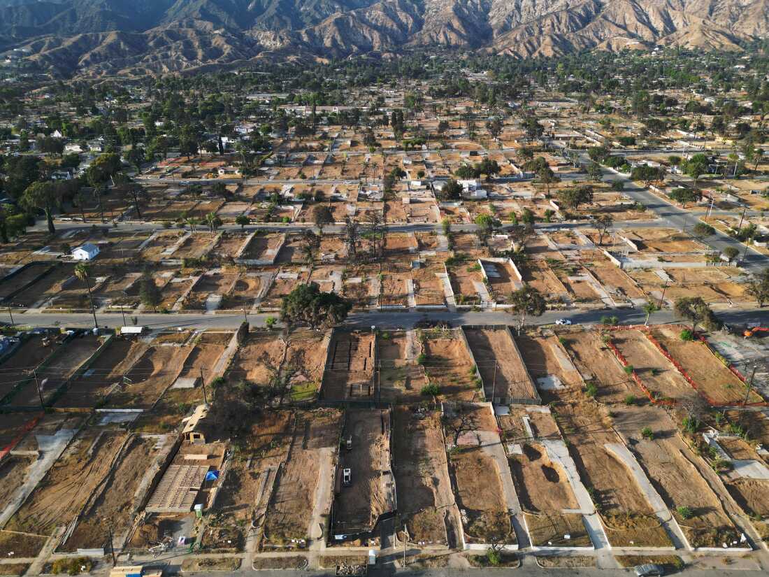 Une vue aérienne montre des terrains résidentiels dégagés, avec les montagnes de San Gabriel en arrière-plan, à Altadena, en Californie, en août 2025, après que l'incendie d'Eaton a détruit plus de 9 000 structures.
