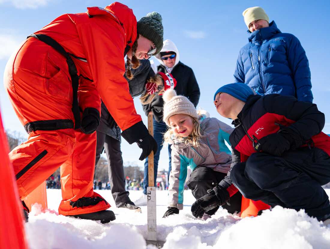 Lincoln Haldeman, à droite, et sa sœur Piper, au centre, mesurent l'épaisseur de la glace avec Helen Schlimm, à gauche, chercheuse au UW-Madison Center for Limnology, lors d'une démonstration scientifique au Frozen Assets Festival sur le lac Mendota le samedi 7 février 2026, à Madison, Wisconsin. Photo de Kayla Wolf