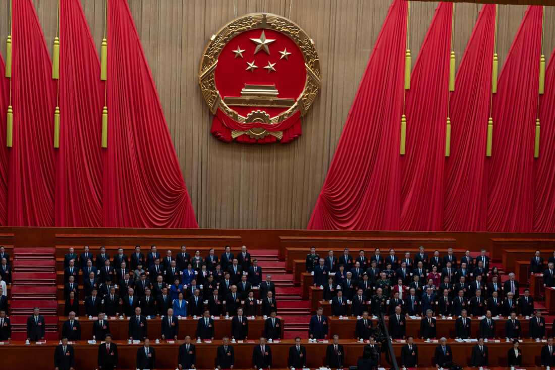 Des délégués, dont le président chinois Xi Jinping (au centre), se lèvent pendant que l'hymne national est chanté lors de la séance de clôture de l'Assemblée populaire nationale au Grand Palais du Peuple à Pékin, jeudi.