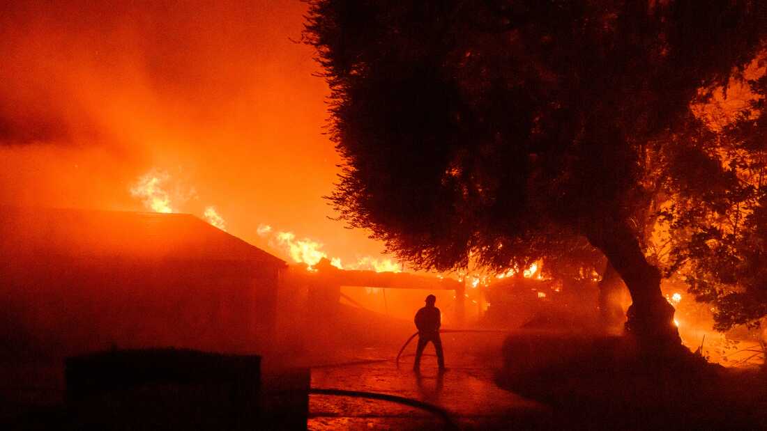 Un pompier travaille alors que des maisons brûlent lors de l'incendie d'Eaton dans la région d'Altadena, dans le comté de Los Angeles, en Californie, le 7 janvier 2025. 