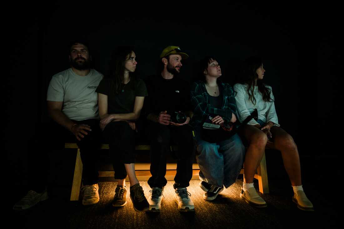 Un groupe d'amis est assis dans la galerie d'exposition de la RAF et regarde FRAMERATE : Desert Pulse le 14 avril 2026 au Desert Botanical Garden à Phoenix, en Arizona.
