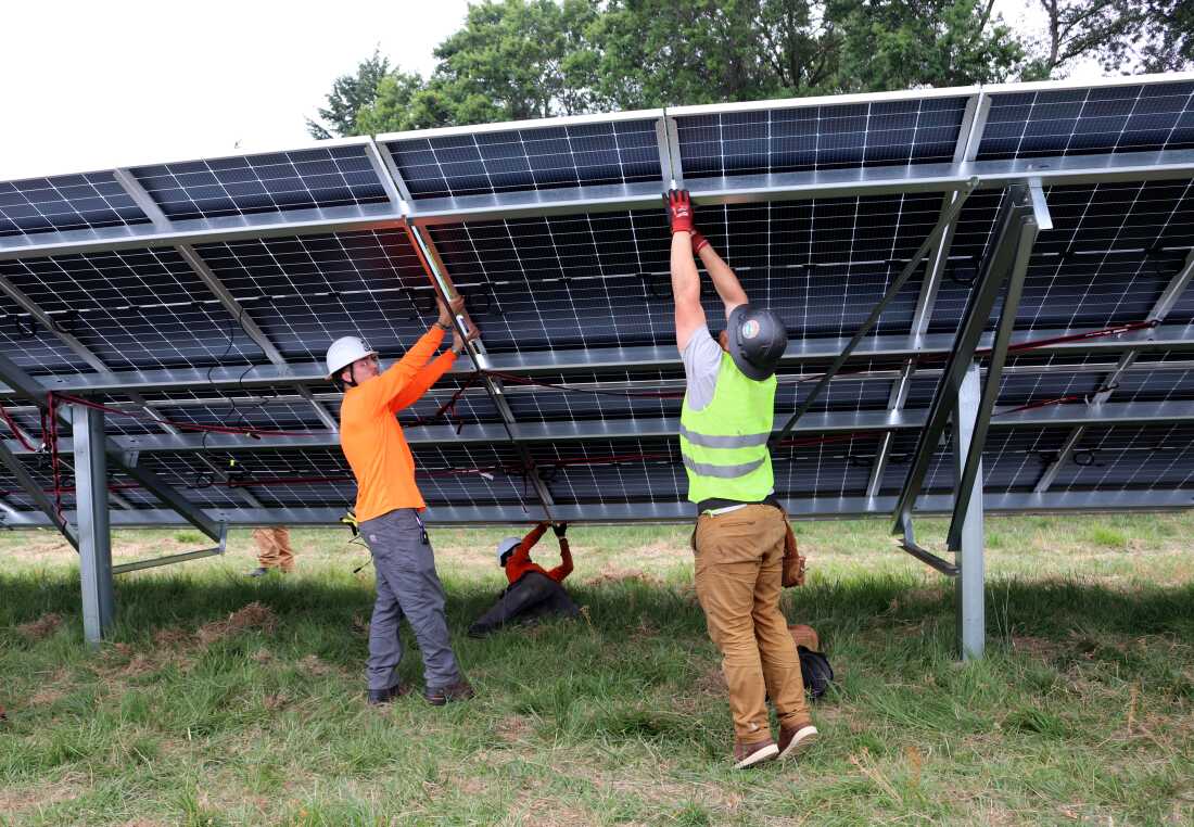 Deux ouvriers ont assemblé un panneau solaire qui fait partie d'un projet solaire communautaire à Portland, dans l'Oregon.  