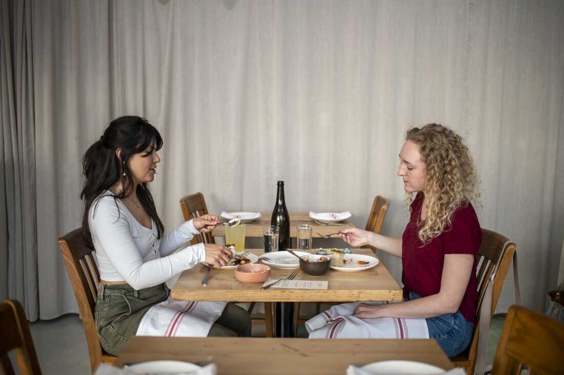 Michelle Valencia et Erin Weber dînent à L'Oca d'Oro le mardi 17 février 2026, à Austin, Texas. L'Oca d'Oro propose une promotion le mardi soir où les clients peuvent payer ce qu'ils veulent. Avec la hausse des prix des denrées alimentaires, de plus en plus d’Américains restent à la maison plutôt que de sortir dîner. Sergio Flores/NPR