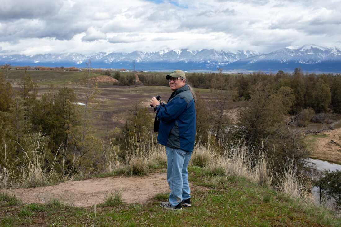 Mike Durglo Jr. se dresse sur une colline au-dessus d'une rivière et regarde vers une chaîne de montagnes. Durglo a consacré sa vie à préparer sa maison et son peuple au changement climatique. En tant que coordinateur du changement climatique des tribus confédérées Salish et Kootenai, il a rédigé l'un des premiers plans d'action tribaux sur le climat du pays il y a plus de 15 ans.