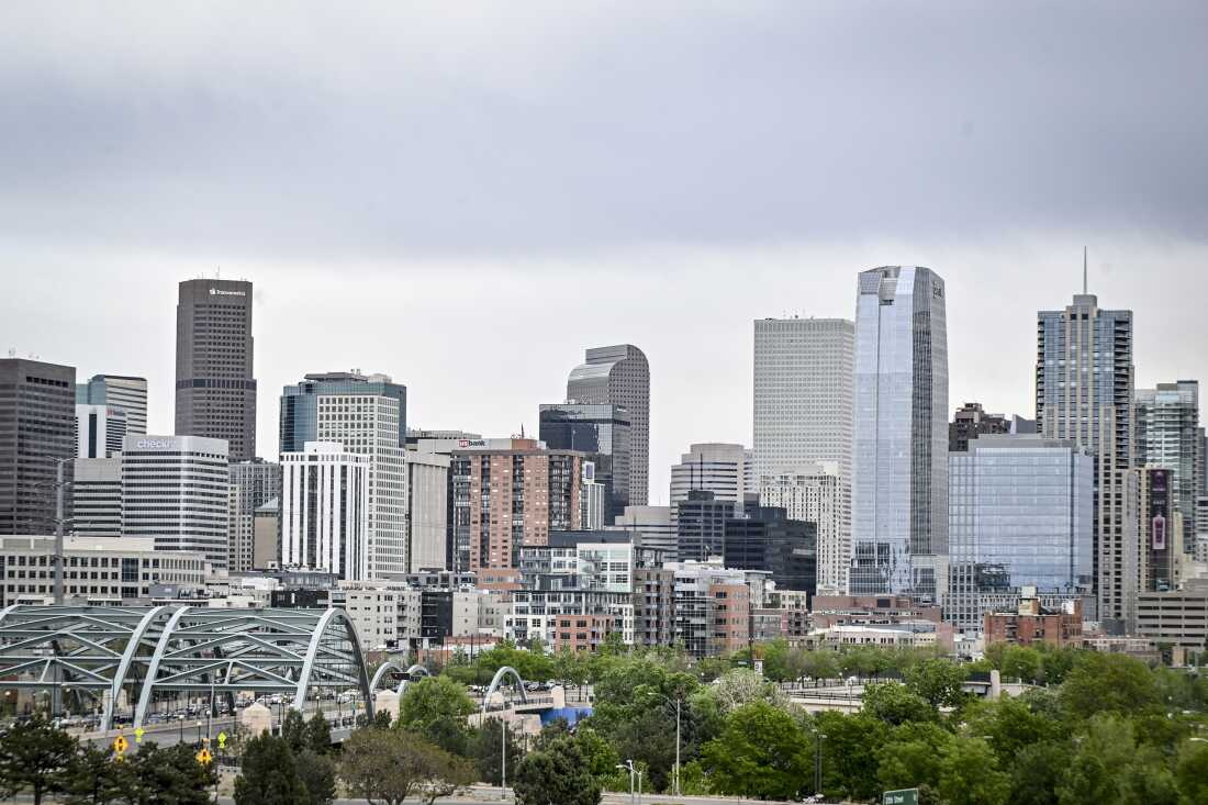 Cette photo montre l'horizon de Denver, avec de nombreux bâtiments hauts et modernes.