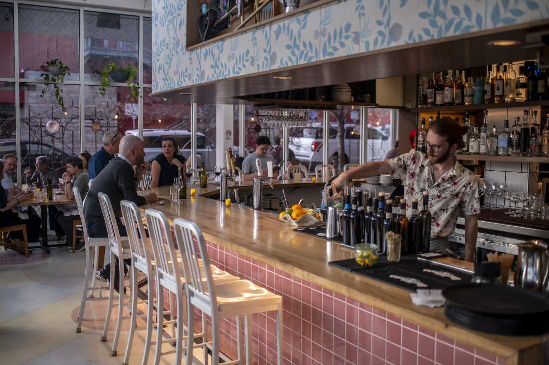 Un barman sert un verre à L'Oca d'Oro, un restaurant italien d'Austin, au Texas, qui propose une promotion hebdomadaire où les clients peuvent payer ce qu'ils veulent.