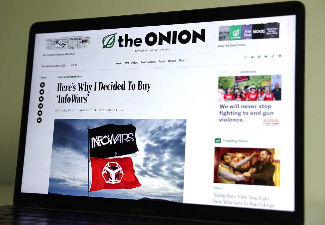 Dans cette illustration photographique, le site Web The Onion est affiché sur un écran d'ordinateur, montrant une histoire satirique intitulée Voici pourquoi j'ai décidé d'acheter « InfoWars ».