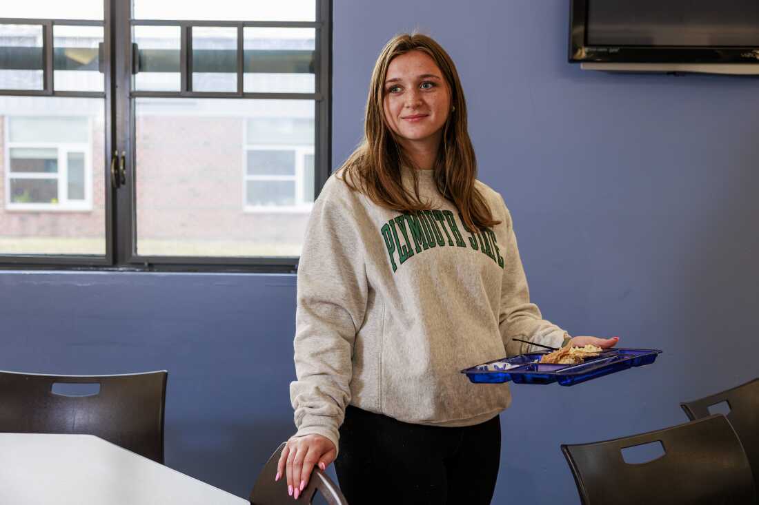 Mady Worcester se tient à l'école, tenant dans une main une assiette de cafétéria remplie de tacos au poisson.