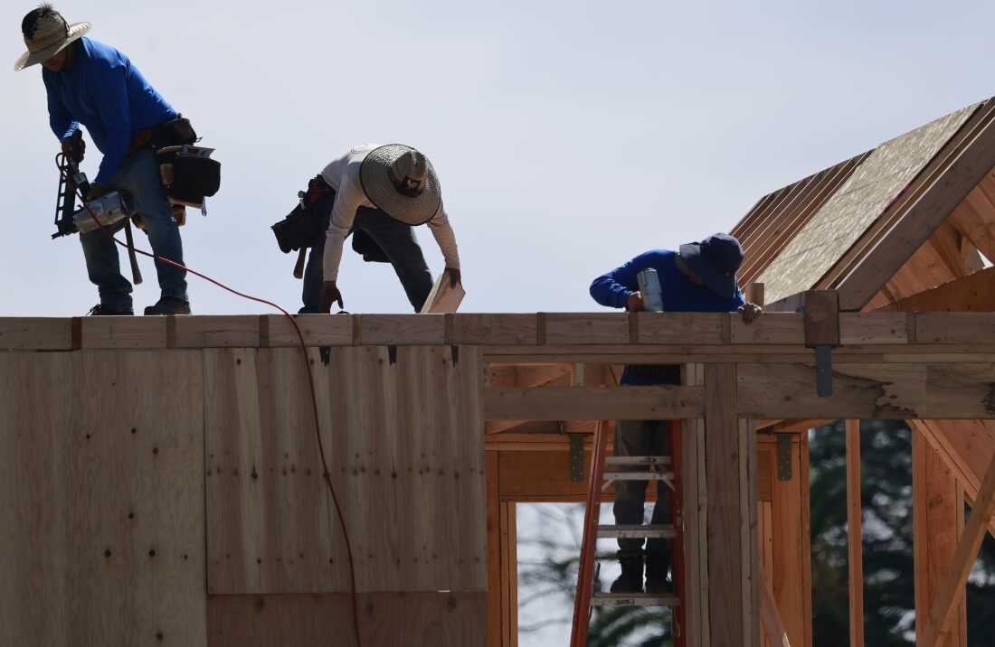 Des ouvriers du bâtiment reconstruisent une maison dans la zone brûlée d’Eaton Fire en mars à Altadena, en Californie.