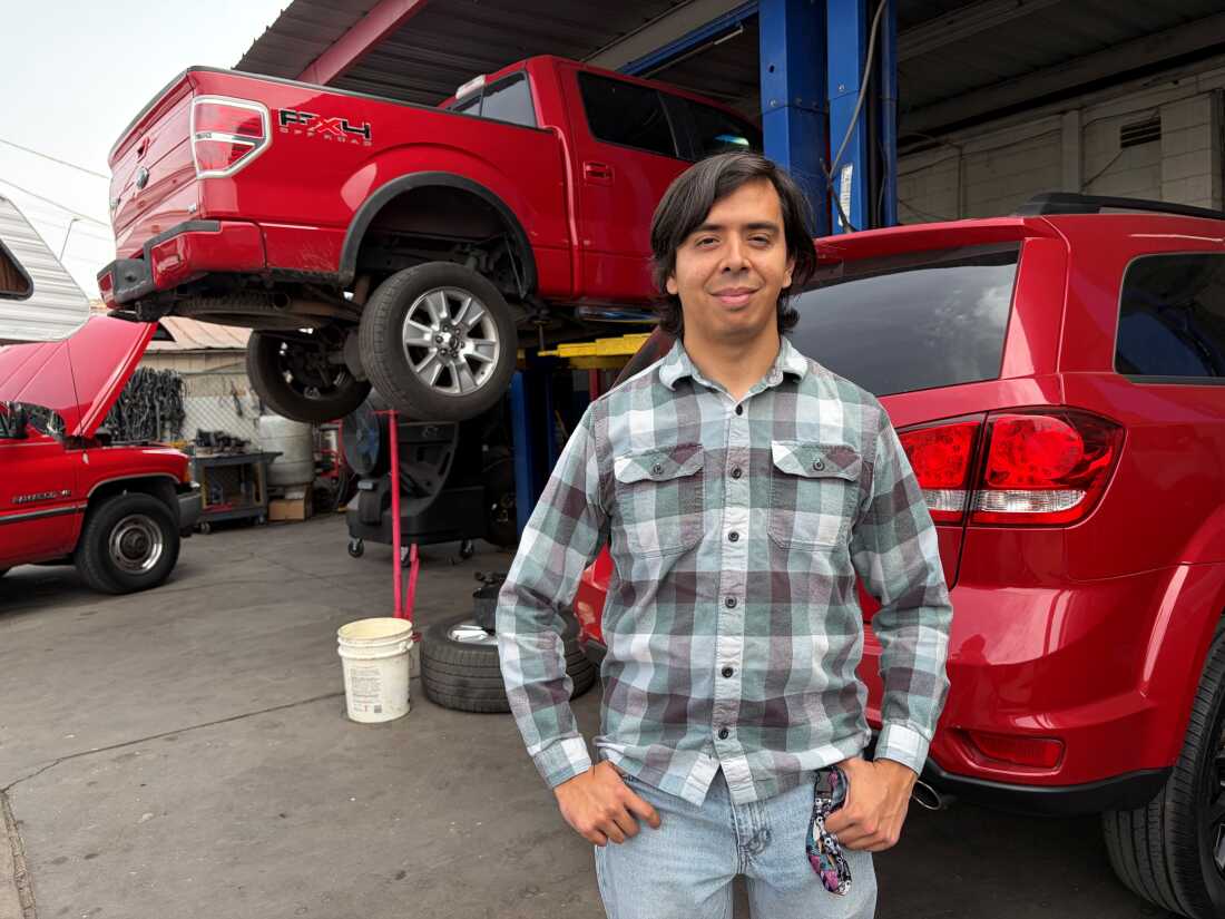 Guadalupe Higuera se tient devant des camions en réparation dans l'atelier de sa famille à Phoenix.