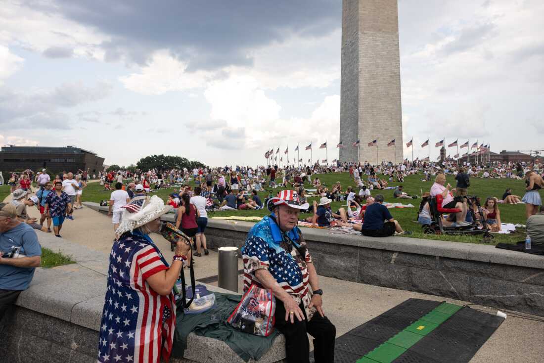 Les gens sont assis près du Washington Monument devant le "Salut à l'Amérique 250" rassemblement sur le National Mall lors d'une célébration du 250e jour de l'indépendance américaine le 4 juillet 2026 à Washington, DC.