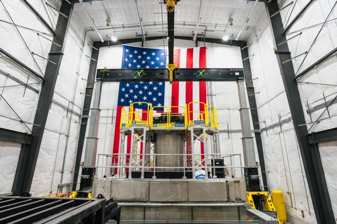 Le réacteur d'essai critique Aalo-X d'Aalo Atomics se trouve à l'intérieur des installations de l'entreprise à Idaho Falls, dans l'Idaho. Un grand drapeau américain est accroché verticalement sur le mur du fond de l'établissement.
