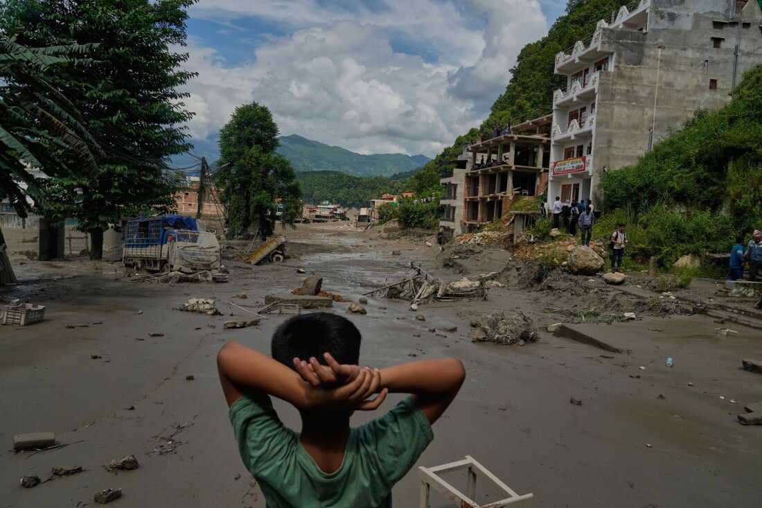 Un garçon regarde les ravages causés mercredi par les crues soudaines le long de la rivière Trishuli, dans le district de Nuwakot au Népal.