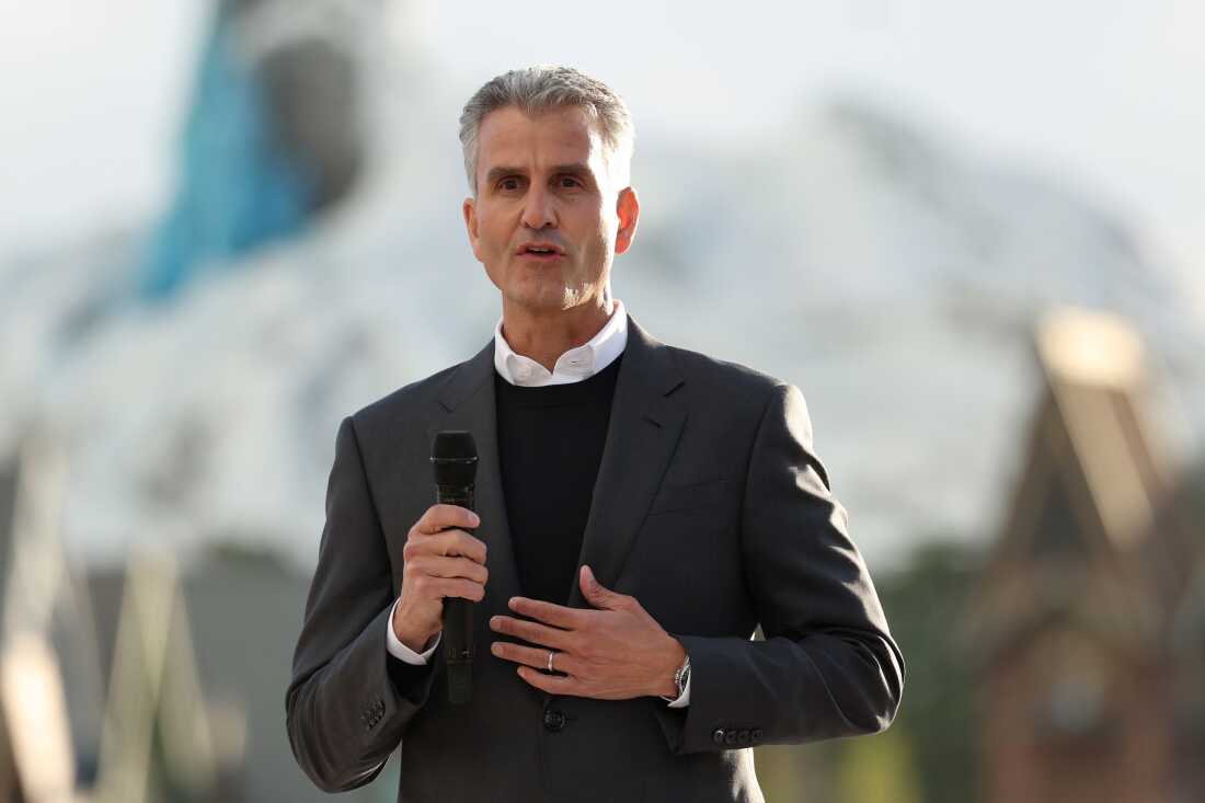 Josh D'Amaro, PDG de Disney, debout à l'extérieur et tenant un microphone, assiste à la journée presse de Disney Adventure World et World of Frozen à Disneyland Paris le 28 mars.