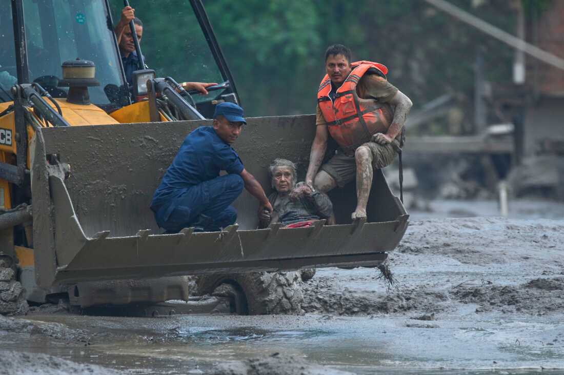 Les sauveteurs utilisent une engin de terrassement pour transporter une victime d'inondations soudaines en lieu sûr le long de la rivière Trishuli, dans le district de Nuwakot au Népal, le mercredi 26 août 2026.