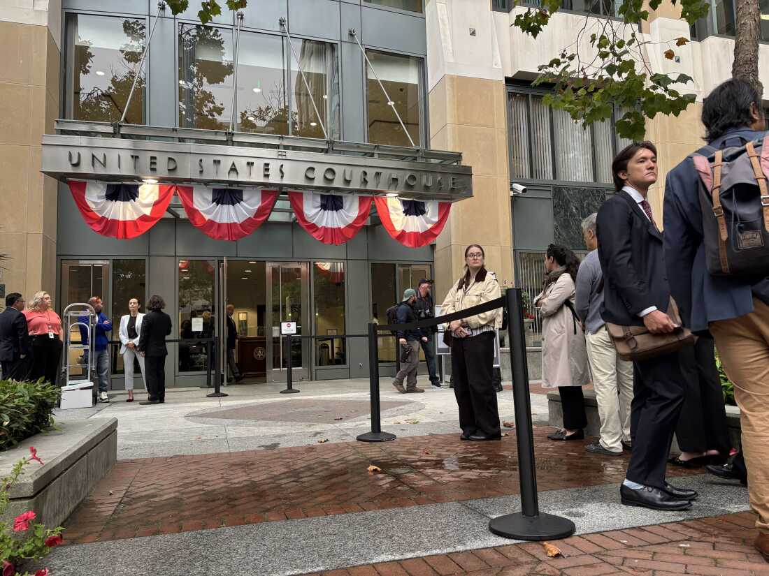 Des gens font la queue devant le palais de justice fédéral d'Oakland, en Californie, avant l'ouverture des plaidoiries du procès que quatre procureurs généraux de l'État intentent contre Meta Platforms, Inc.