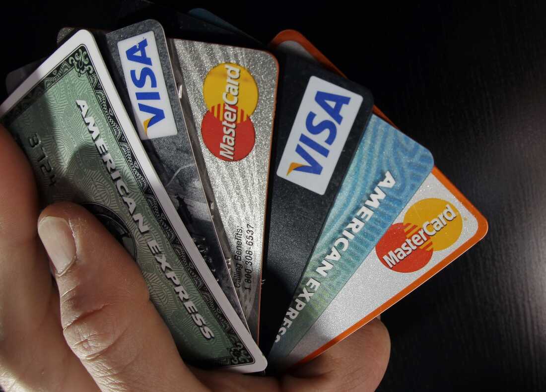 Un gros plan montre une main tenant diverses cartes de crédit.