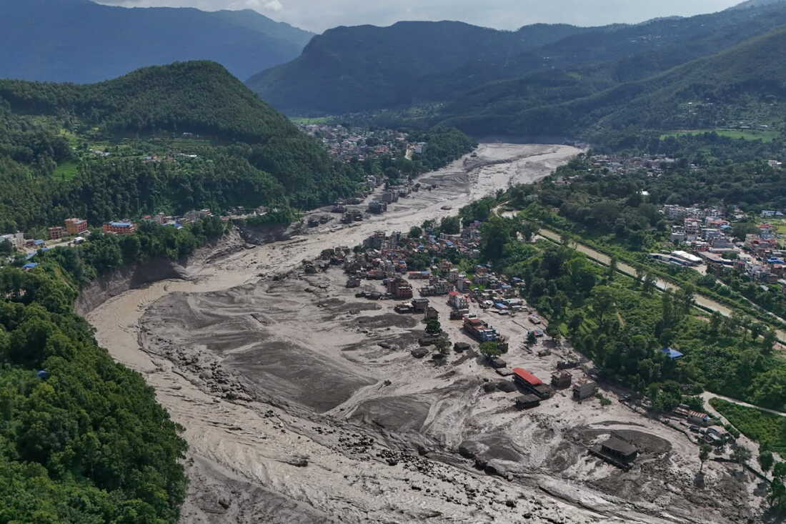 Des maisons endommagées se dressent de manière précaire près des berges gonflées et obstruées par les débris de la rivière Trishuli après des crues soudaines dans le district de Nuwakot au Népal mercredi.