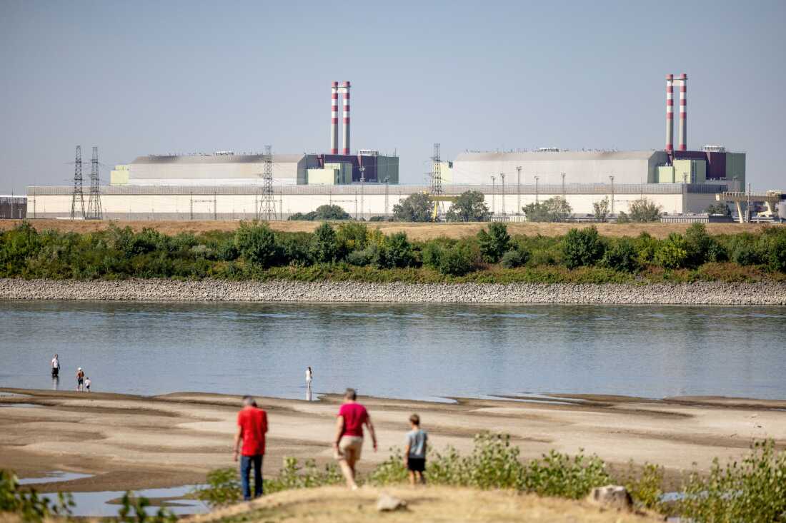 Vue de la centrale nucléaire hongroise de Paks depuis la digue du Danube à Dunaszentbenedek le 31 juillet 2026. Les niveaux d'eau record sur le Danube, provoqués par une chaleur extrême et une sécheresse, ont menacé le système de refroidissement de la centrale et mis en évidence l'aggravation de la crise climatique en Europe.
