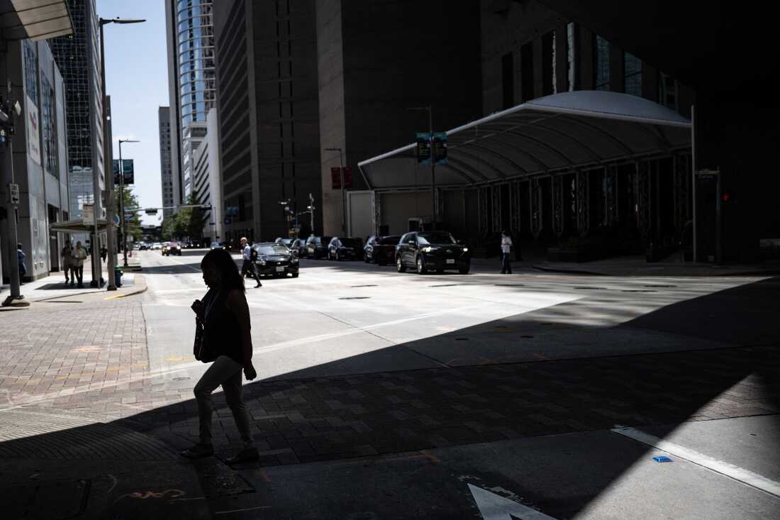 Une femme marche à l’ombre dans le centre-ville de Houston, au Texas, fin juillet 30, lors d’une vague de chaleur régionale.