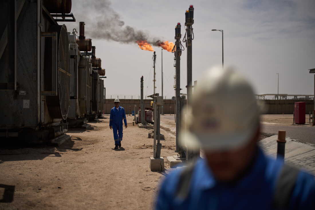 Des ouvriers marchent dans le champ pétrolier de Zubair, dont les opérations ont été réduites depuis le début de la guerre en Iran, près de Bassorah, en Irak, le 28 mars.