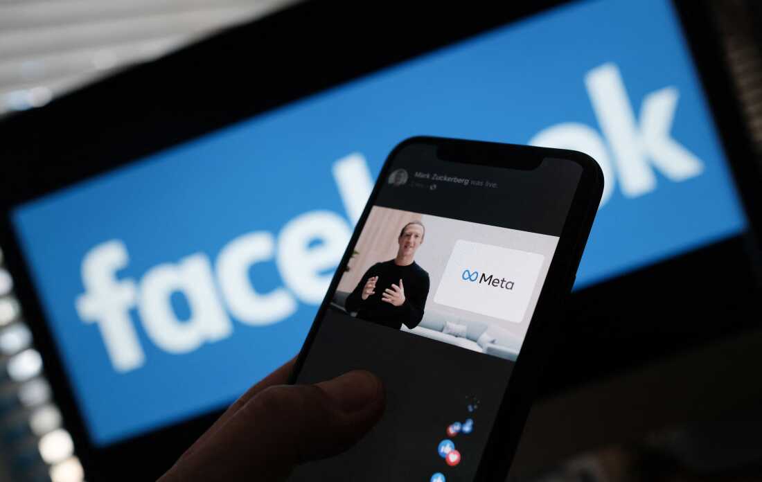 Sur cette photo d'illustration prise à Los Angeles le 28 octobre 2021, une personne regarde sur un smartphone le PDG de Facebook, Mark Zuckerberg, dévoiler le logo Meta.
