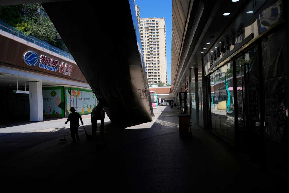 Un travailleur ramasse des déchets dans un complexe commercial Evergrande partiellement fermé, le jour où la Bourse de Hong Kong a radié le promoteur immobilier chinois China Evergrande, à Pékin, en Chine, le 25 août 2025.