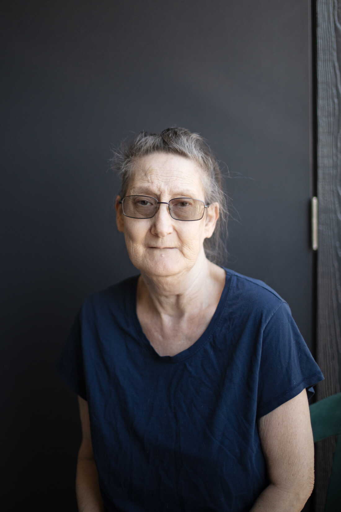 Debbie Willson porte un T-shirt foncé et des lunettes.