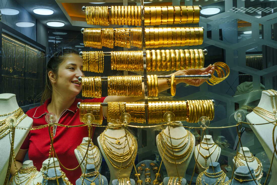 Une bijoutière sort des bracelets en or d'une vitrine du Grand Bazar pour les montrer aux clients à Istanbul, en Turquie, le 20 août 2026.
