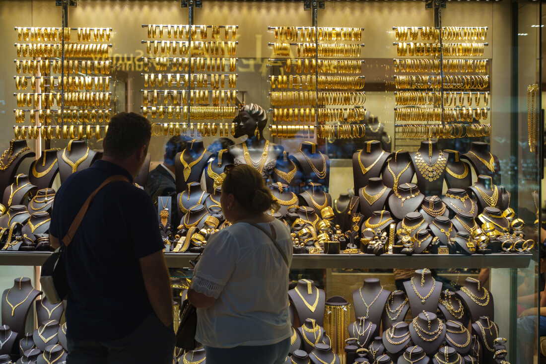 Un couple regarde des bijoux en or dans le Grand Bazar d'Istanbul, en Turquie, le 26 août 2026. Le ministre turc des Finances, Mehmet Şimşek, a déclaré qu'environ 640 milliards de dollars d'or et de devises étrangères sont détenus en dehors du système financier. Pour de nombreux épargnants turcs, l’or physique reste un moyen sûr de protéger leur argent de l’inflation et de l’incertitude économique. Cette pratique est connue sous le nom de « yastık altı altın », ou « de l’or sous le matelas », en référence à la tradition selon laquelle la richesse est conservée dans des actifs physiques plutôt que dans des banques.
