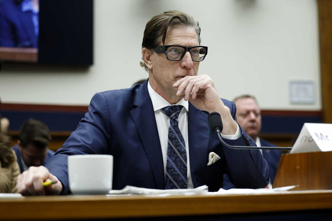 David Richardson témoigne devant le Congrès en 2025, alors qu'il dirigeait l'Agence fédérale de gestion des urgences (FEMA). Il porte un costume bleu marine, une cravate à rayures bleu marine et des lunettes à monture épaisse et sombre.
