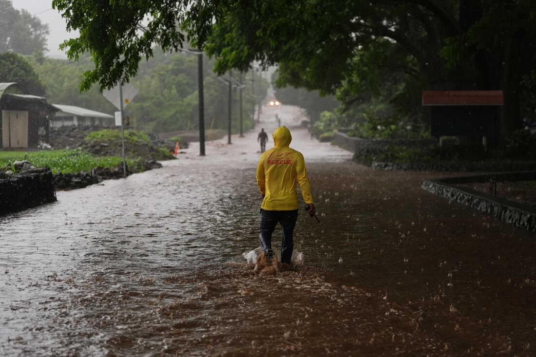 Le capitaine des pompiers Lui Sales du service d'incendie d'Hawaï cherche des résidents pour aider alors que les eaux de pluie de l'ouragan Nolo à proximité inondent une section de l'autoroute Mamalahoa le samedi 26 septembre 2026, près de Naalehu, à Hawaï.