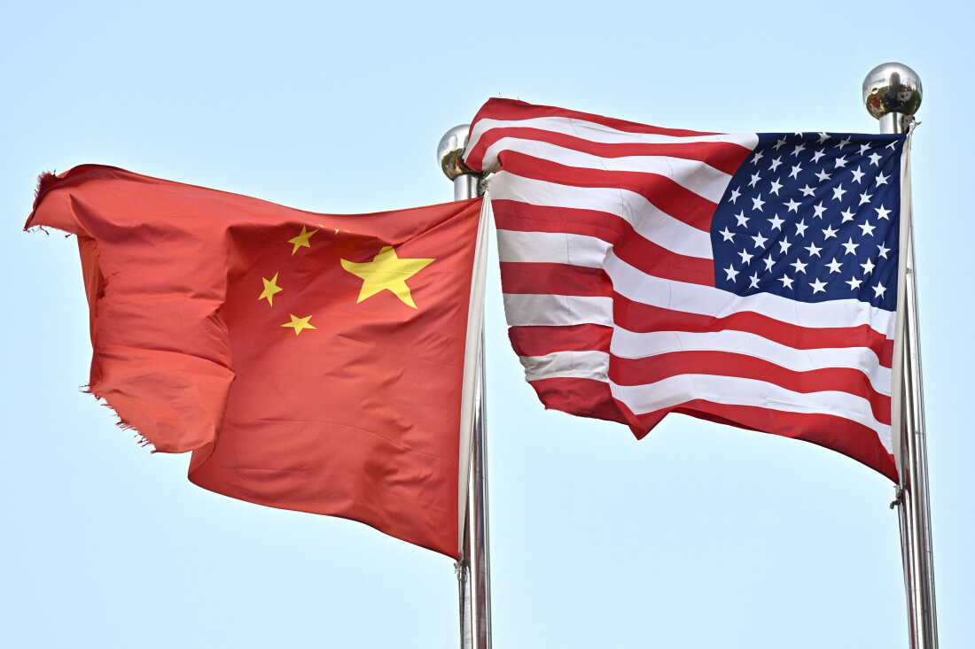 Des drapeaux chinois et américains flottent devant une entreprise technologique à Pékin, le 17 avril 2025. La Chine a demandé à Washington le 16 avril de "arrêtez de menacer et de faire chanter" après que le président américain Donald Trump a déclaré qu'il appartenait à Pékin de venir à la table des négociations pour discuter de la fin de leur guerre commerciale. Trump a imposé de nouveaux droits de douane à ses amis et à ses ennemis, mais a réservé ses coups les plus durs à la Chine, avec 145 pour cent sur de nombreuses importations chinoises, alors même que Pékin a riposté avec des prélèvements de 125 pour cent sur les produits américains. (Photo de Pedro Pardo / AFP) (Photo de PEDRO PARDO/AFP via Getty Images)