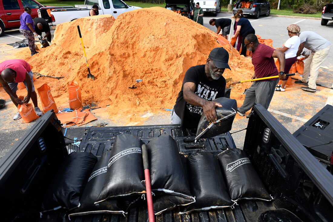 Les résidents ramassent des sacs de sable pour se préparer à la tempête au James Seals Jr. Parks & Recreation Centre avant l'arrivée prévue de l'ouragan Isaias le long de la côte du Golfe, le jeudi 8 octobre 2026, à Mobile, en Alabama.