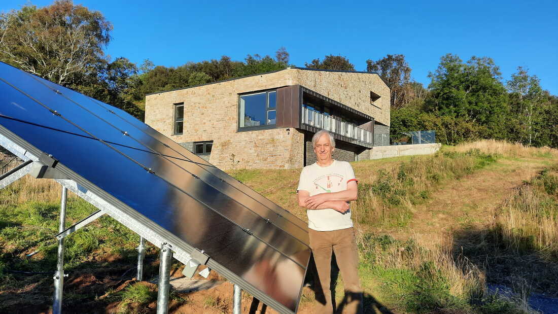 Mike Coe devant sa « Passivhaus » sur l’île de Skye en Écosse, qu’il a construite avec sa partenaire Lizzie après avoir décidé de déménager vers le nord pour des étés plus frais.