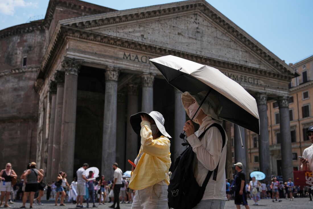 DOSSIER – Des touristes utilisent des parapluies pour se protéger du soleil sur la place du Panthéon à Rome, le 29 juin 2026.