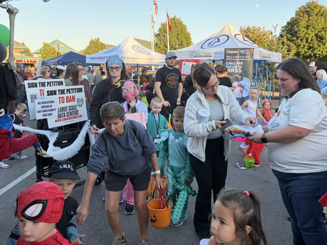 Linda Moodie (à droite), bénévole de Conserve Ohio, recueille des signatures pour une pétition visant à interdire les centres de données à grande échelle dans tout l'État lors d'un événement d'Halloween à Fairfield, Ohio, le 22 octobre 2026.