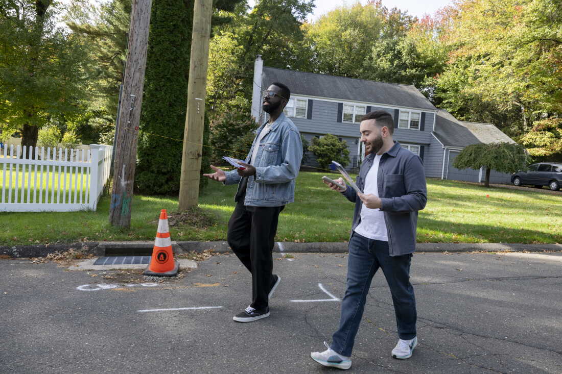 Olaleye Onikuyide (à gauche) et son directeur de campagne, Karo Shakhnazarov, marchent dans une rue du quartier alors qu'ils font du démarchage à West Hartford, Connecticut, le 10 octobre 2026.