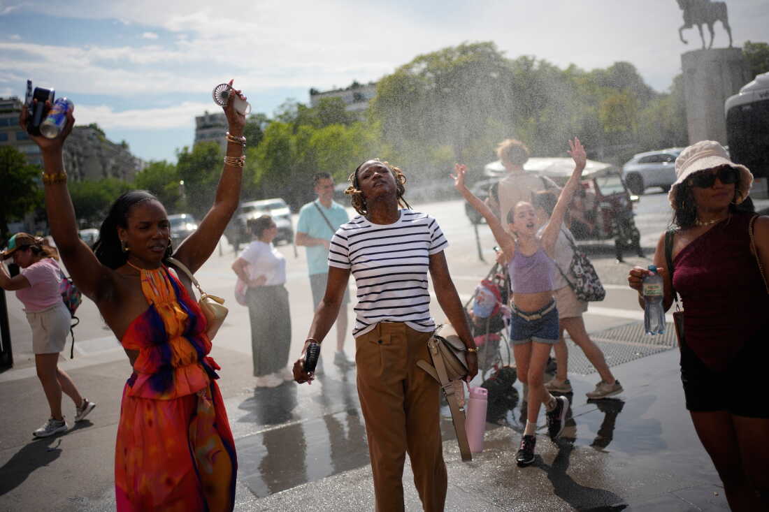 DOSSIER – Des gens se rafraîchissent à une fontaine publique à Paris, le 26 juin 2026.