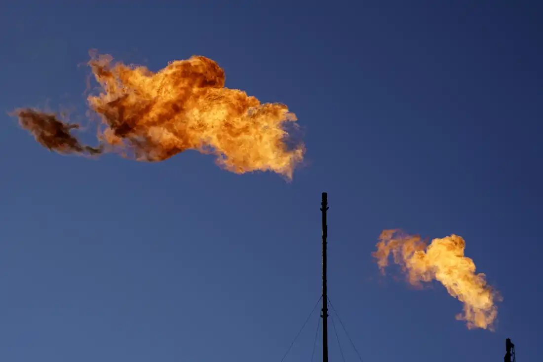 Des torchères brûlent du méthane et d'autres hydrocarbures dans une installation pétrolière et gazière à Lenorah, Texas, le 15 octobre 2021.