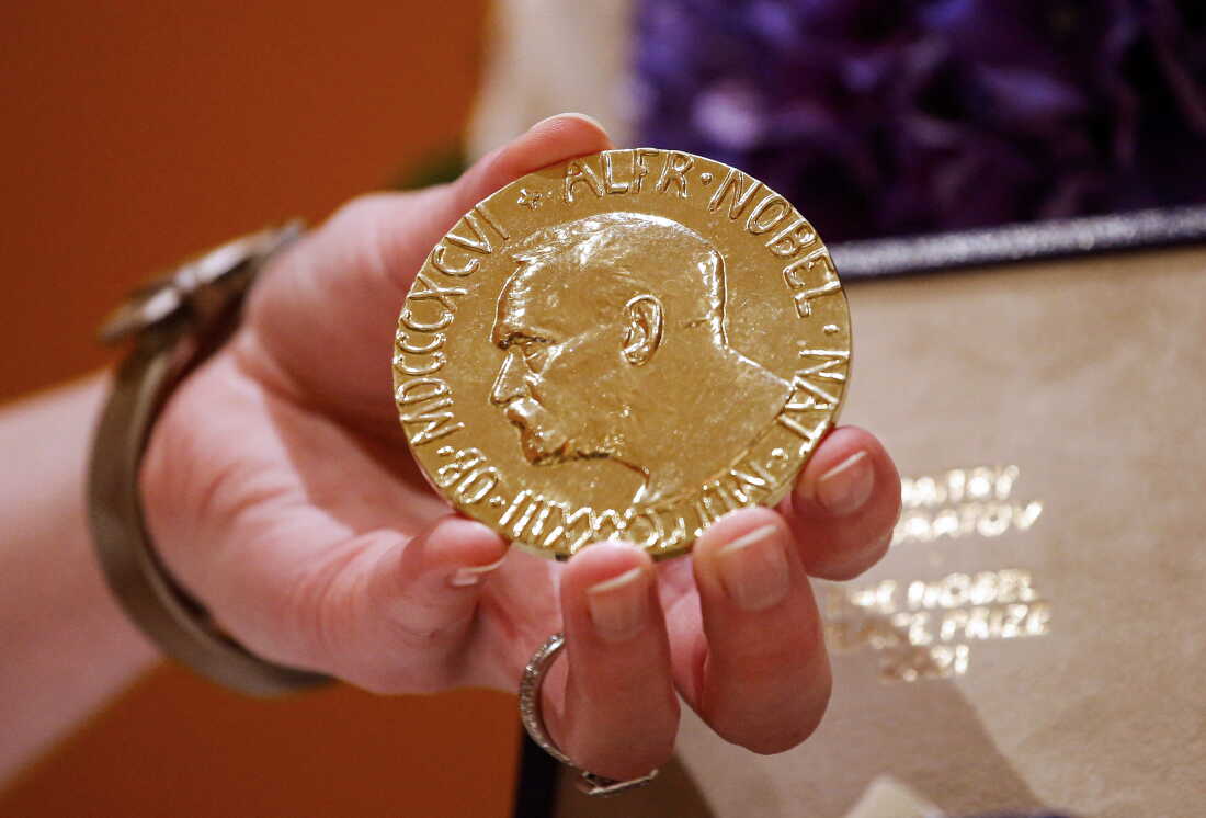 Une femme détient la médaille du prix Nobel de la paix 2021 décernée au journaliste russe Dmitri Muratov à New York en 2022.